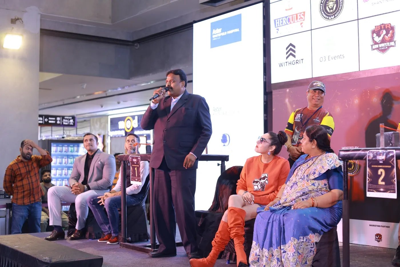 R. S. Dharmendra speaking at the 6th BCAI Arm Wrestling National Championship 2026 at Nexus Shantiniketan Mall, Bengaluru